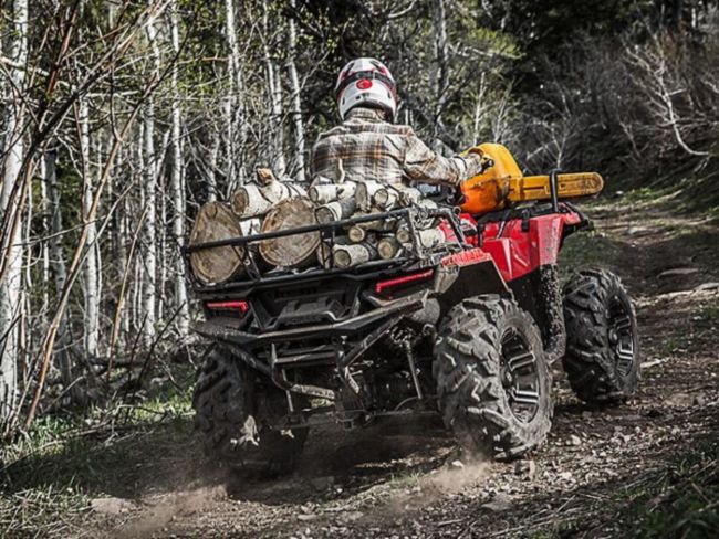 2018 Polaris® Sportsman® carrying chopped wood driving down trail in forest